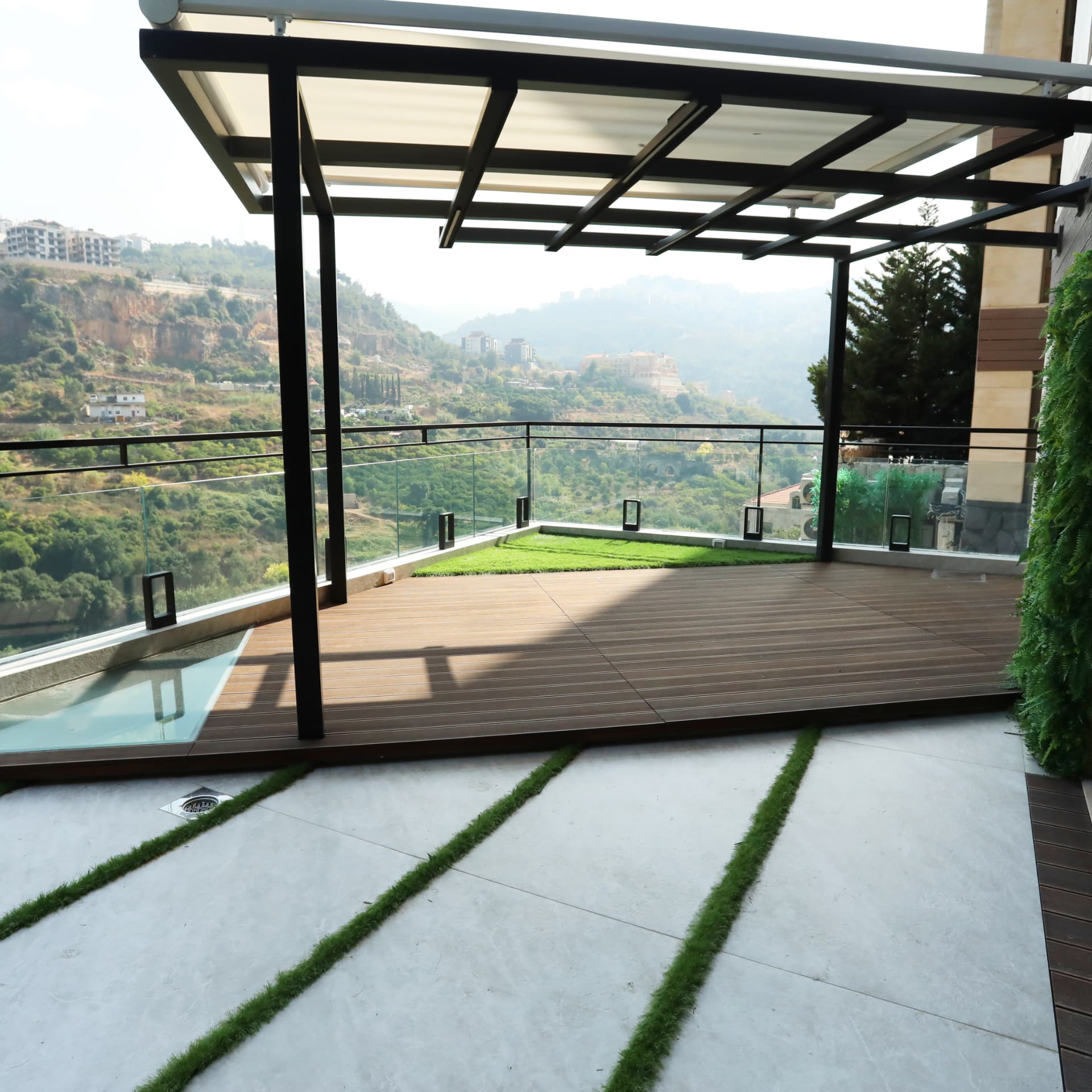 Shaded terrace with timber deck, pergola and glass balustrade