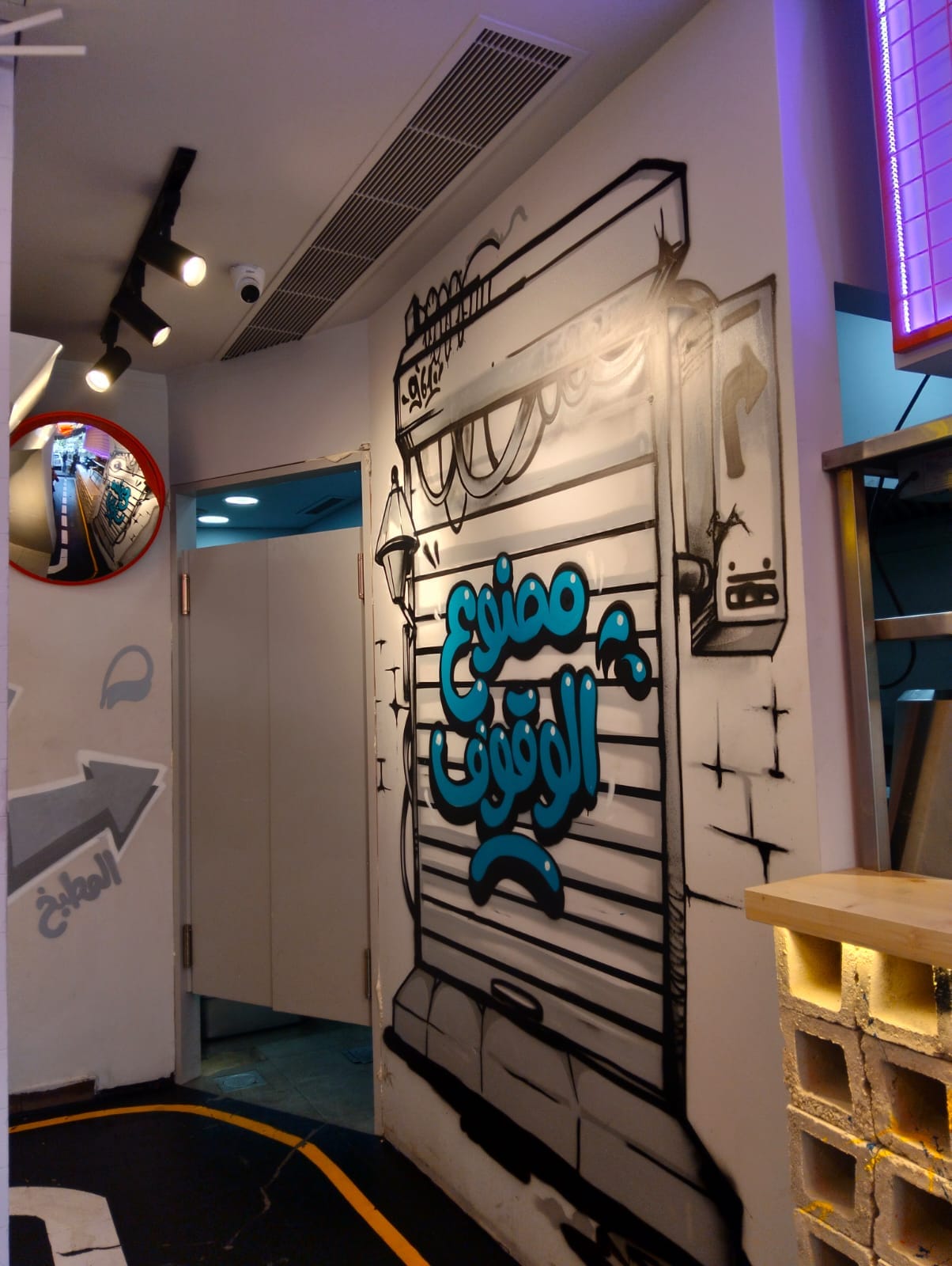 Circulation corner with Arabic graffiti shutter mural and block work
