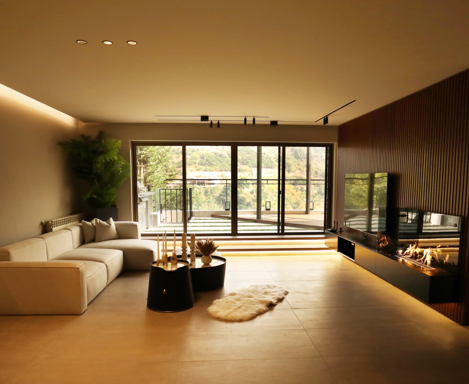 Living room with linen sectional, ribbed timber wall and linear fireplace