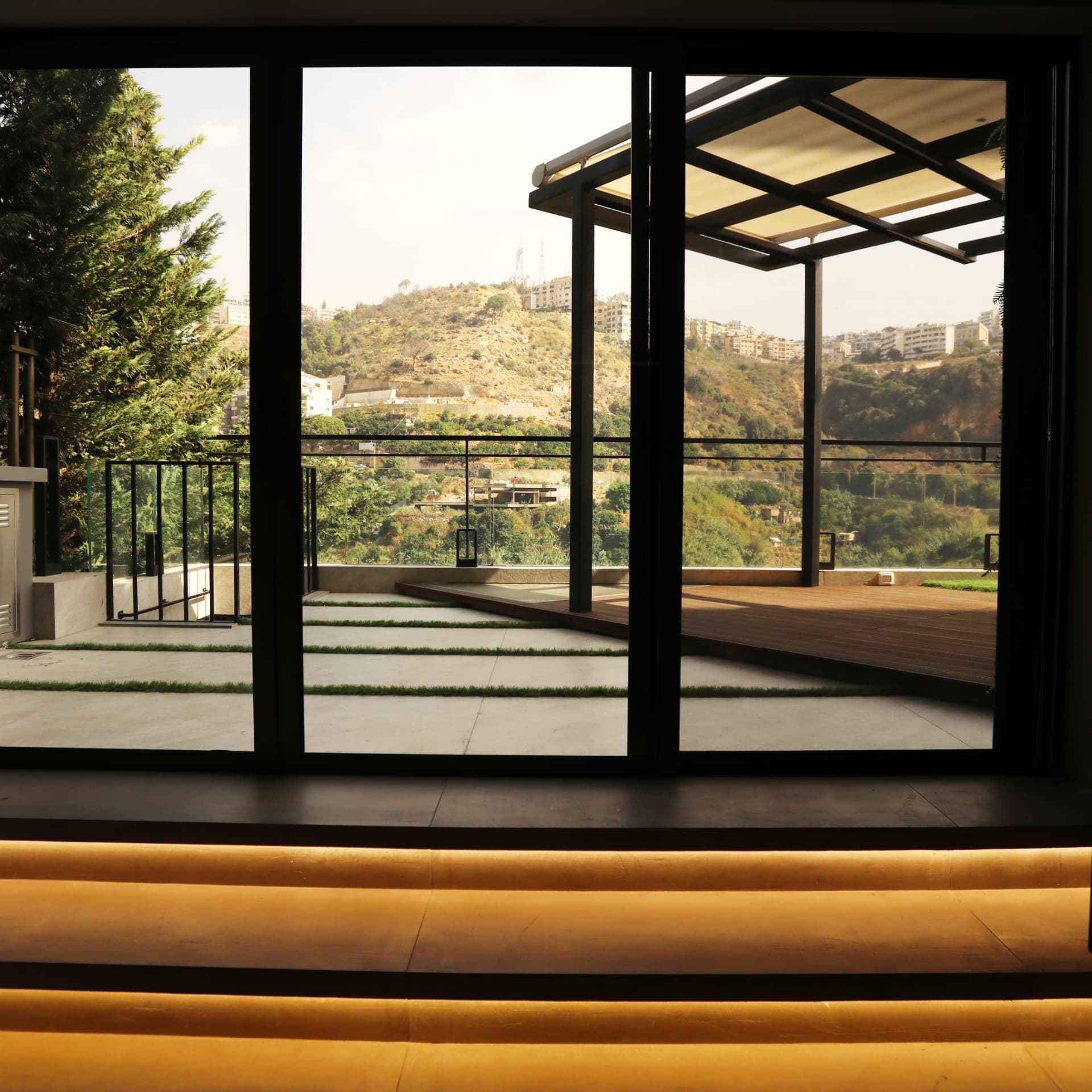 Sliding glass wall framing the terrace and valley beyond