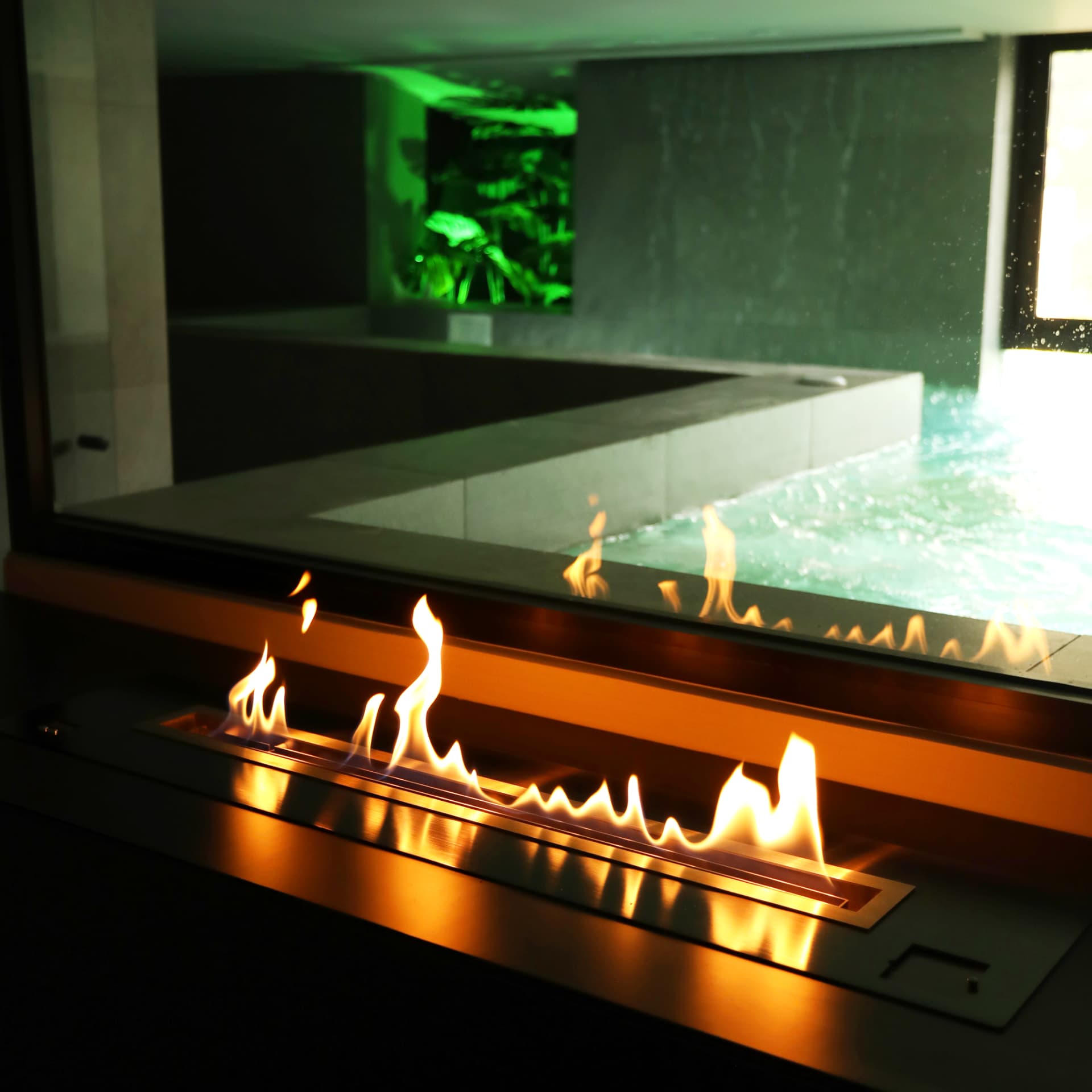 Linear fireplace beside the indoor pool