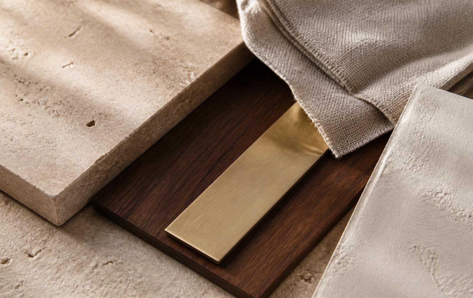 Travertine, walnut, brass and linen samples forming a material palette